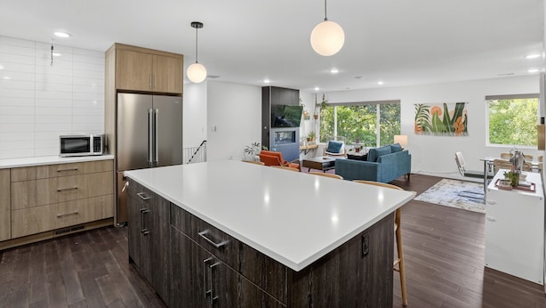 A modern kitchen with a large island, wooden cabinets, and stainless steel appliances. - Modern Urban Retreat, Game Room (Portland)