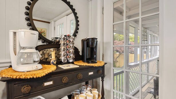 A coffee station with a Cuisinart coffee maker, a black coffee maker, and a coffee mug display. - Walk Downtown! SUNY, near Power Plants, Hospital, Pets. 3 bathrooms, King beds! (Oswego)