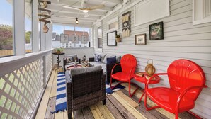 A covered porch with wicker furniture, red chairs, and a ceiling fan. - Walk Downtown! SUNY, near Power Plants, Hospital, Pets. 3 bathrooms, King beds! (Oswego)