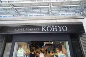 The entrance to a Super Market named Kohyo with a modern design and a covered entrance. - AIROSE Yodoyabashi (Osaka)
