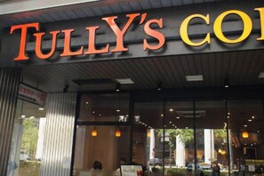A restaurant with a prominent sign reading 'TULLY'S CO' and a visible menu board outside. - AIROSE Yodoyabashi (Osaka)