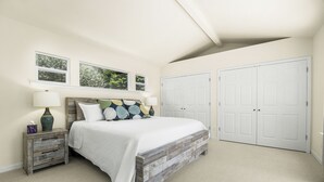 A bedroom with a bed, nightstands, a window, and a closet. - Sleeps 8 in the Jewell Box close to Privates and Pleasure Point (Santa Cruz)