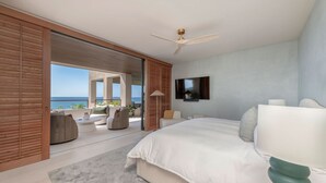 A bedroom with a large bed, a TV mounted on the wall, and a view of the sea. - Condo Surf Sea Streich (Punta Mita)
