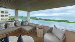 A modern outdoor seating area with a view of the ocean and greenery. - Condo Surf Sea Streich (Punta Mita)