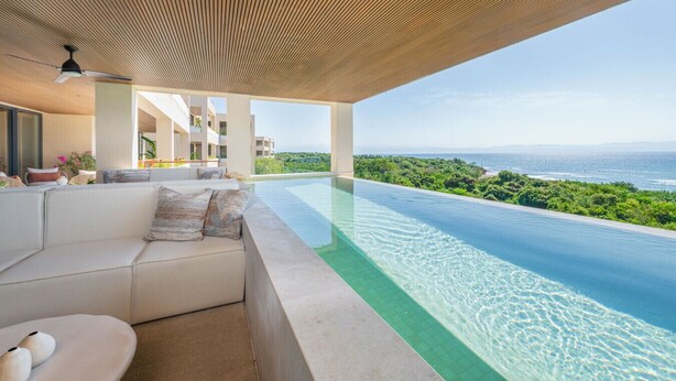 A modern infinity pool with a clear view of the ocean and greenery. - Condo Surf Sea Streich (Punta Mita)
