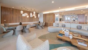 A modern living room with a sofa, chairs, a coffee table, and pendant lights. - Condo Surf Sea Streich (Punta Mita)