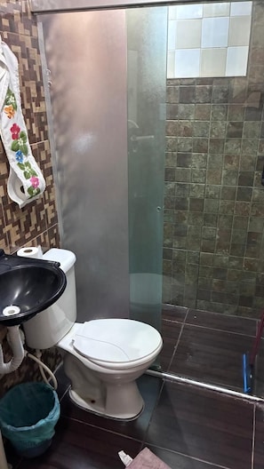 A bathroom with a toilet, a bidet, a shower area, and a tiled wall. - Townhouse with pool and air conditioning near Caraguatatuba shopping mall (Caraguatatuba)