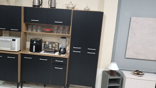A kitchen with a microwave, coffee maker, and blender on a wooden countertop. - Townhouse with pool and air conditioning near Caraguatatuba shopping mall (Caraguatatuba)