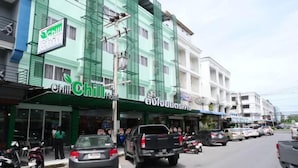 A hotel with a green facade, a sign for 'Chill Chill Hotel', and a visible entrance.