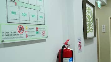 A fire safety sign with emergency exit directions and a fire extinguisher mounted on the wall.