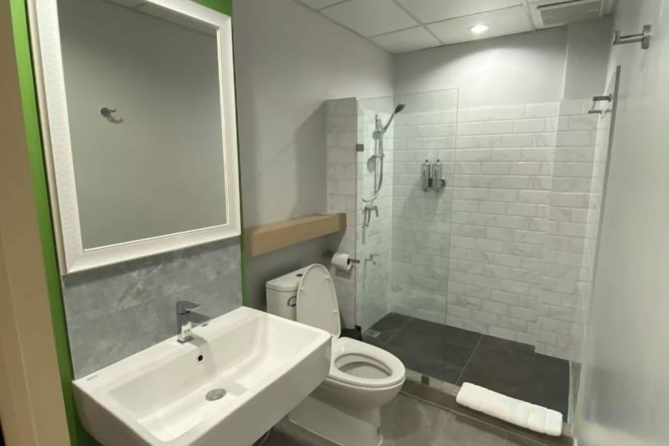 A bathroom with a sink, toilet, and shower area.