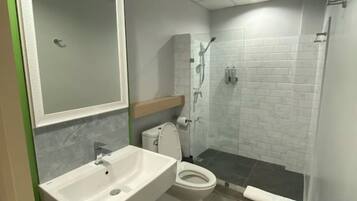 A bathroom with a sink, toilet, and shower area.