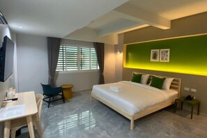 A modern hotel room with a bed, desk, chair, and a small table. - Chill Chill Hotel (Krabi)