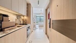 Una cucina moderna con mobili in legno, forno integrato e un piano di lavoro con macchina per il caffè.