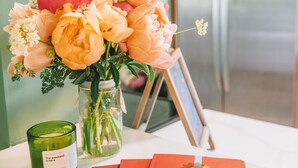 Ein Tisch mit Blumen in einer Vase, einer Kerze und einem roten Notizbuch.