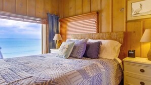 Dormitorio de cabaña de madera con cama, almohadas y mesita de noche.