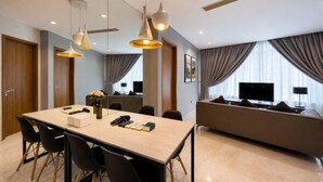 Une chambre d’hôtel moderne dotée d’un coin repas, d’un canapé et d’une télévision.