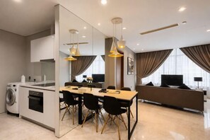 Una cocina moderna con comedor, un espejo grande y una televisión.