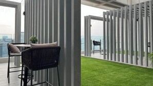 Ein modernes Interieur mit einem Balkon, der eine Rasenfläche und einen Blick auf die Stadt bietet.