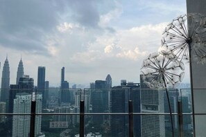 A cityscape with modern buildings and a Ferris wheel. - Agile Bukit Bintang Suites at TRX KL (Kuala Lumpur)