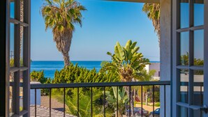 Ein Balkon mit Blick auf das Meer und Palmen.
