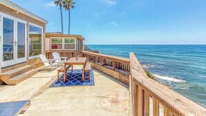 A beachfront property with a deck, outdoor seating, and a view of the ocean. - Ocean Beach Cliffs Sanctuary Oceanfront (San Diego)
