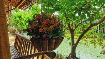 A wooden bench with a hanging planter of flowers.