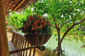 Eine hölzerne Bank mit einem hängenden Blumenkasten.