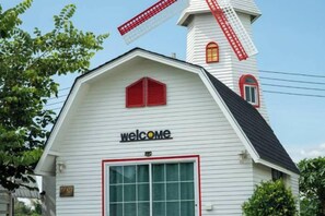 Un edificio blanco con un molino rojo y un letrero que dice 'welcome'.