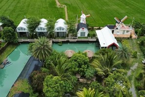 A large estate with multiple white domed buildings, a windmill, and a swimming pool surrounded by lush greenery. - khao Thung Benja HomeStay (Phayuha Khiri)