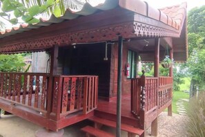 Une structure en bois dotée d’un balcon et d’une entrée couverte.