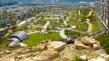 A landscaped garden with pathways, large rocks, and a small pavilion.