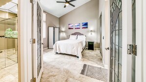 A bedroom with a bed, a ceiling fan, and artwork on the wall. - Whitewater Village Charm - 30 Night Minimum (Oceanside)