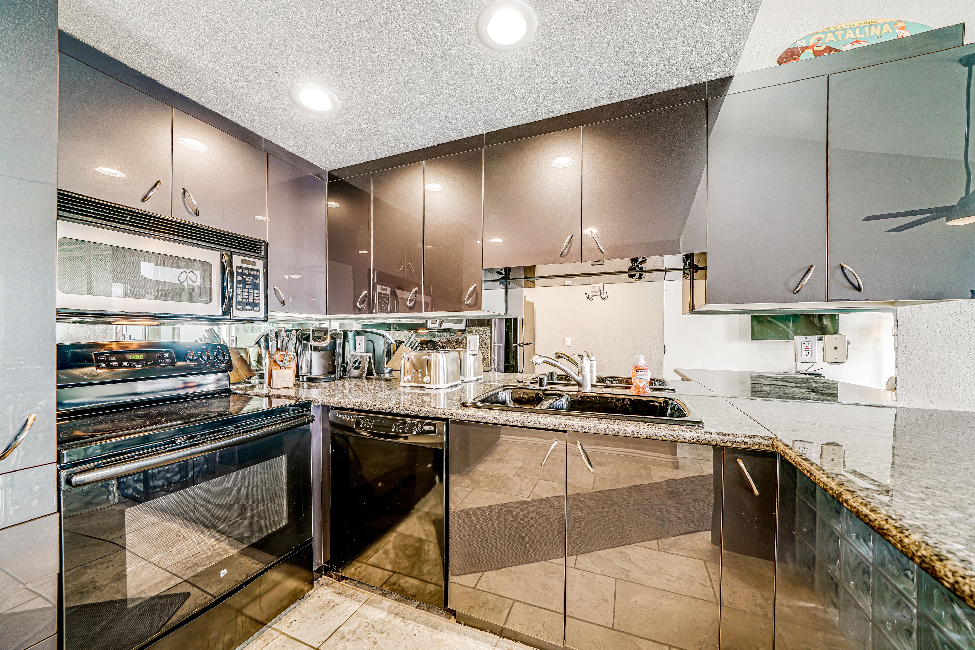 A modern kitchen with stainless steel appliances, a dishwasher, and a granite countertop.