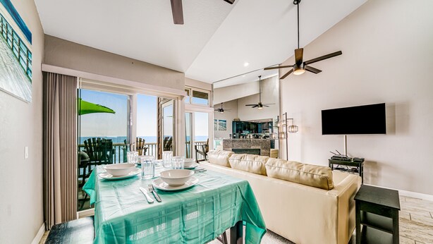 A modern kitchen with a dining area, a sofa, and a TV. - Whitewater Village Charm - 30 Night Minimum (Oceanside)