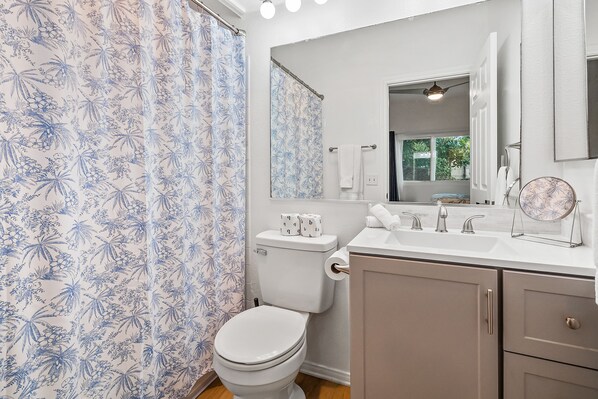 A bathroom with a toilet, sink, and mirror.