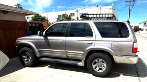 Un SUV plateado estacionado en una calle residencial.