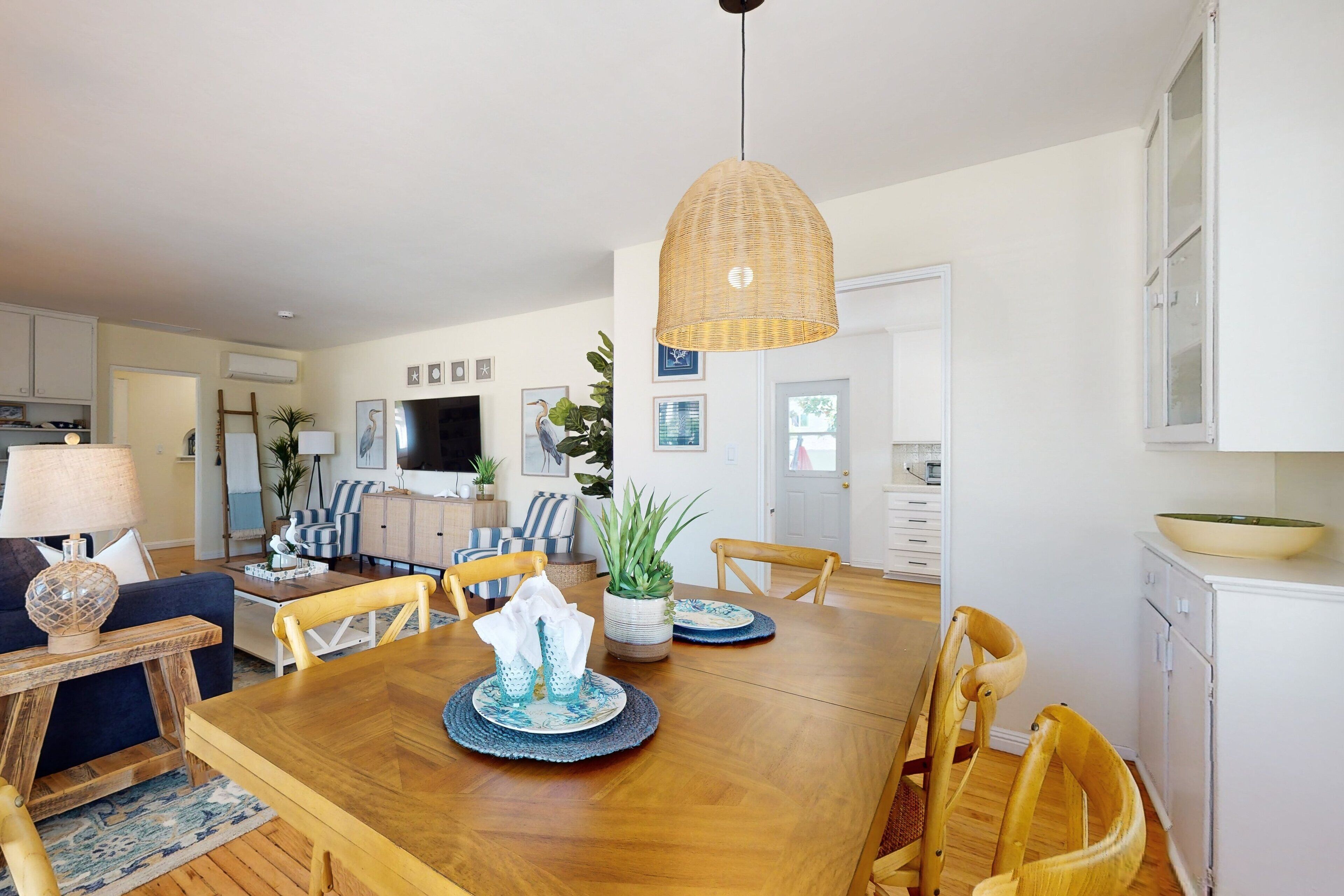 A dining area with a wooden table, chairs, and a hanging light fixture.