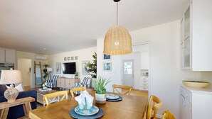 Comedor con una mesa de madera, sillas y un lámpara colgante.