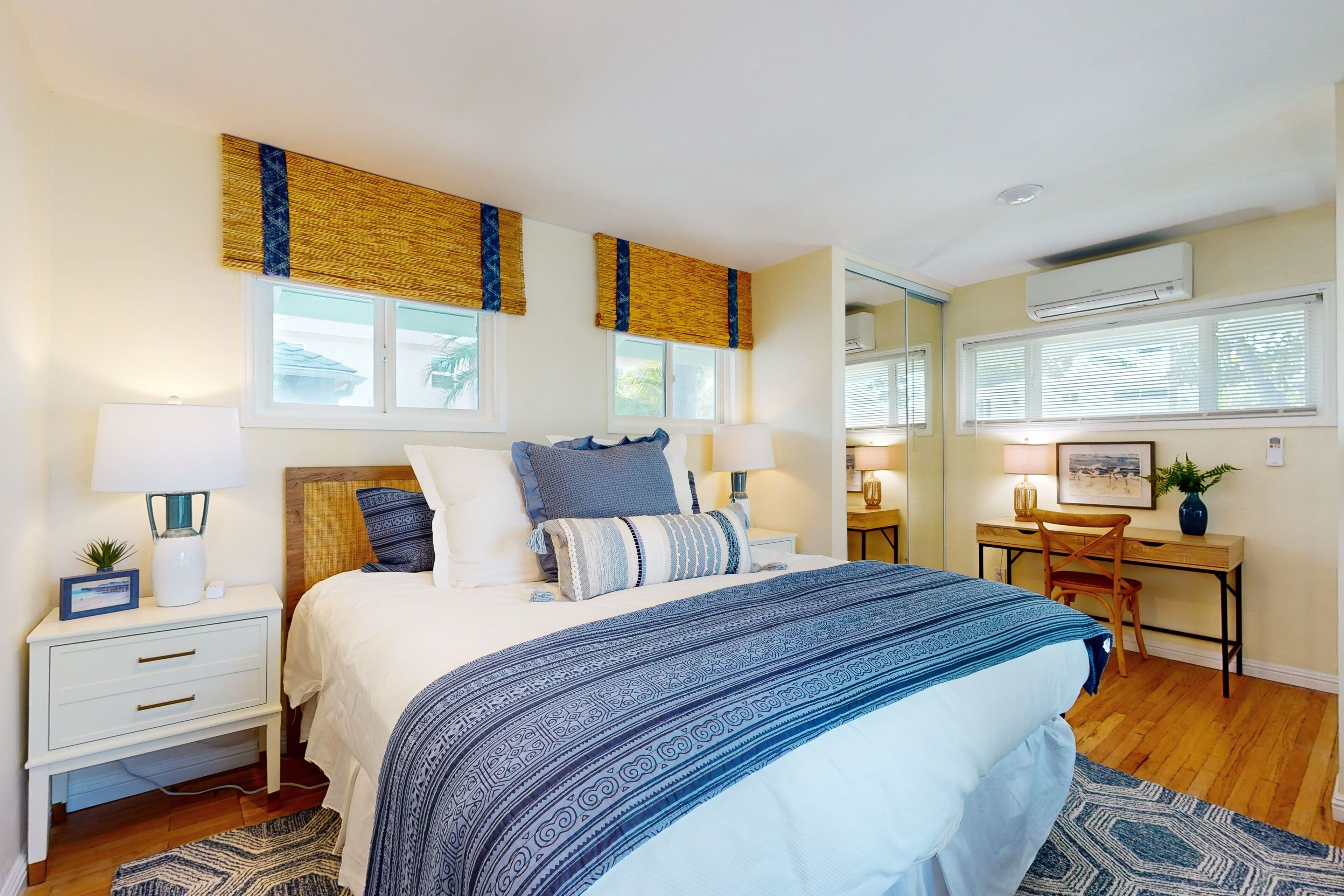 A bedroom with a bed, bedside tables, a desk, and a chair.