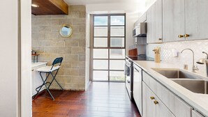 Eine moderne Küche mit großem Fenster, einem Einbauofen und einem Spülbecken.