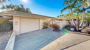 A residential property with a garage, a driveway, and a small garden with palm trees. - Forever Views Oceanfront (La Jolla)