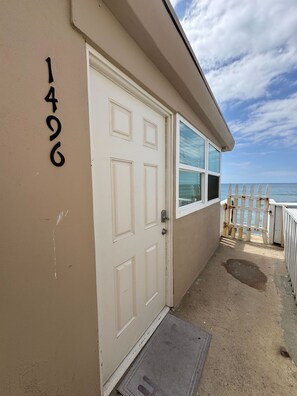 A building with a white door, a window, and a number '1496' on the wall.
