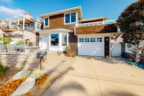 Ein modernes, zweistöckiges Haus mit Garage, Steinmauer und gepflegtem Garten.