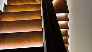 A wooden staircase with a modern design, leading to a higher floor.