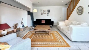 Una sala moderna con un sofá, una mesa de centro y una escalera.