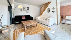 Una sala de estar moderna con un sofá blanco y negro, una mesa de centro de madera y una alfombra estampada.