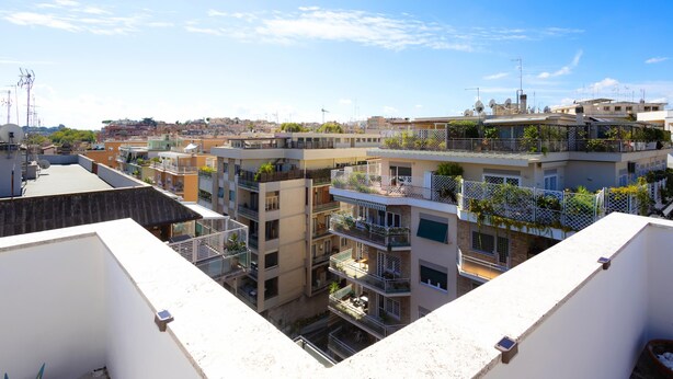 Un immeuble résidentiel à plusieurs étages, doté de balcons, d’une cour intérieure et offrant une vue dégagée sur le quartier environnant.