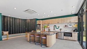 Een moderne keuken met een centraal eiland, barstoelen, houten kastjes en een groot raam met uitzicht.