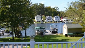 A lakeside view with a dock, boats, and houses in the background. - Lakefront Escape on Highland (Winchester)
